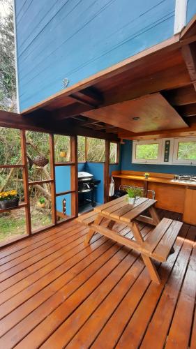 a wooden deck with a picnic table and a grill at Nairandey in La Pedrera