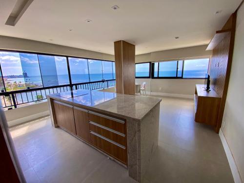 a kitchen with a counter with a view of the ocean at Ondina Apart Hotel Residences in Salvador