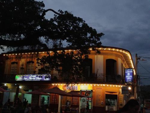 a building with lights on top of it at night at Hotel San Martin Plaza in Villeta