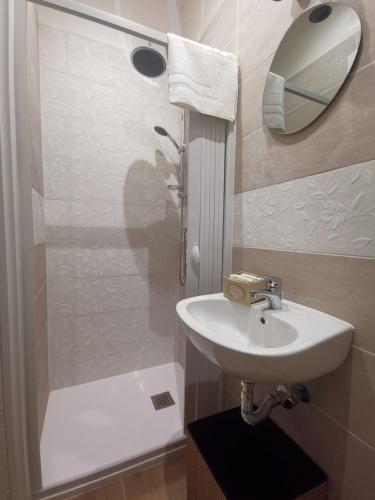 a bathroom with a sink and a shower with a mirror at La Casa delle Tradizioni in Bari