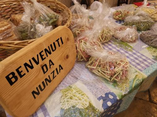 una cesta llena de fideos en bolsas de plástico con una señal en La Casa di Nunzia, en Bari