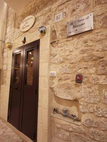 a stone building with a door and signs on it at La Casa delle Tradizioni in Bari