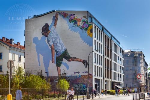 a mural of a man on the side of a building at Fragola Apartments Rajska 3 - modern studios, park in Kraków