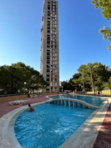 a large swimming pool with a tall building in the background at Benidorm beach, playa de Benidorm in Benidorm