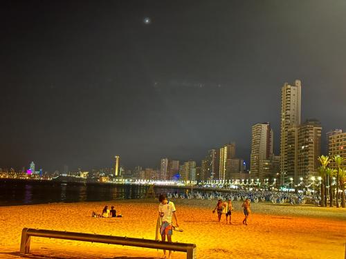 a group of people on a beach at night at Benidorm beach, playa de Benidorm in Benidorm