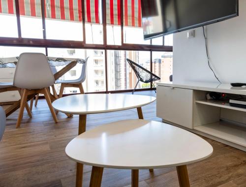 a living room with two tables and a tv at Benidorm beach, playa de Benidorm in Benidorm