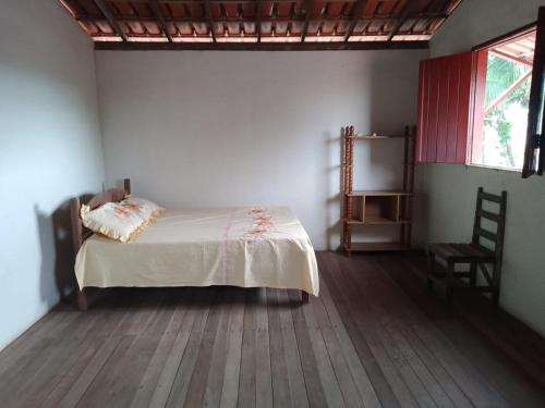 um quarto com uma cama e uma cadeira num quarto em Casa à 200 metros da praia em Porto Seguro