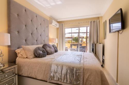 1 dormitorio con 1 cama grande y TV en Terrazas del Duque II Hideaway en Adeje
