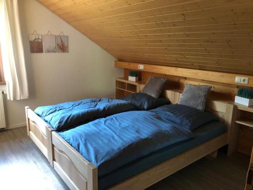 - un lit avec des oreillers bleus dans l'établissement Ferienwohnung Buchenblick, à Monschau