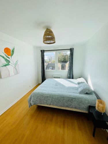 une chambre avec un lit et une fenêtre dans l'établissement La terrasse de Clovis, à Reims