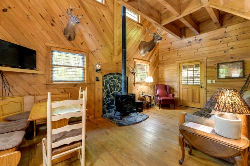 a log cabin with a living room and a fireplace at Hot Tub and Furnished Porch Balsam Grove Cabin in Balsam Grove
