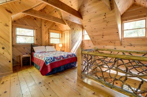 1 dormitorio en una cabaña de madera con 1 cama. en Quiet Balsam Grove Cabin Porch, Hot Tub, Dogs OK, en Balsam Grove