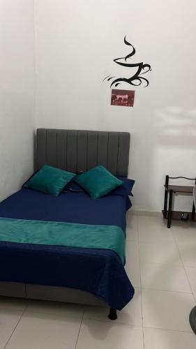 a bedroom with a bed with green pillows at Hotel San Martin Plaza in Villeta