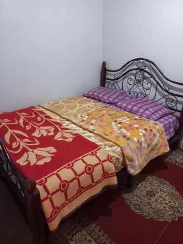 a bed with a quilt on it in a room at Maison d'hôte la source in Ouzoud