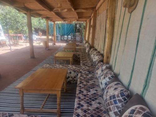 una fila de mesas y bancos en un edificio en Maison d'hôte la source, en Ouzoud