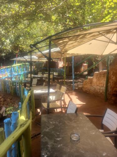 un patio con mesas y sillas bajo una tienda de campaña en Maison d'hôte la source, en Ouzoud
