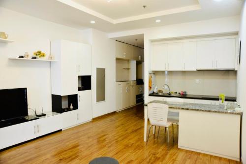 a large kitchen with white cabinets and a wooden floor at Homestay Times City 04T1N in Hanoi