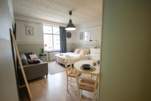 een woonkamer met een tafel en een bank en een kamer bij Atmospheric hundred-year-old stone house apartment near Aurajoki in Turku