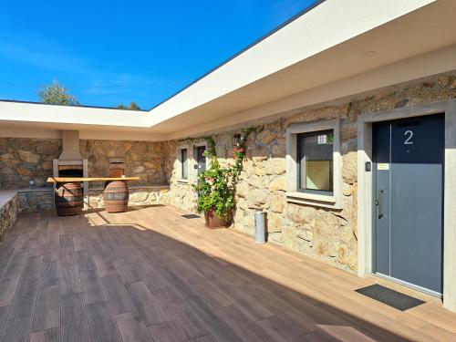a house with a stone wall and a patio at Agrafonte in Paços de Ferreira