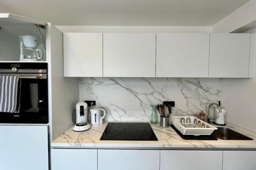 une cuisine avec des armoires blanches et un comptoir dans l'établissement FIRST Modern Studio/ balcony/ free car park/ 2P, à Metz