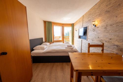 a small room with a bed and a table at Eden Resort Anzère in Anzère