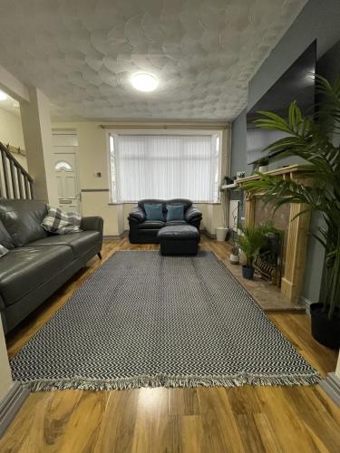 a living room with a couch and a rug at Charlesworth House in Crewe