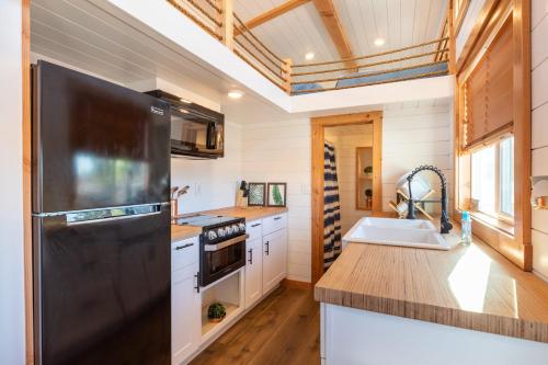 a kitchen with a black refrigerator and a sink at Aloha Tiny Home in Apple Valley