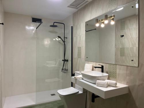 y baño blanco con lavabo y ducha. en Apartamento Campillo 23 Trujillo, en Trujillo