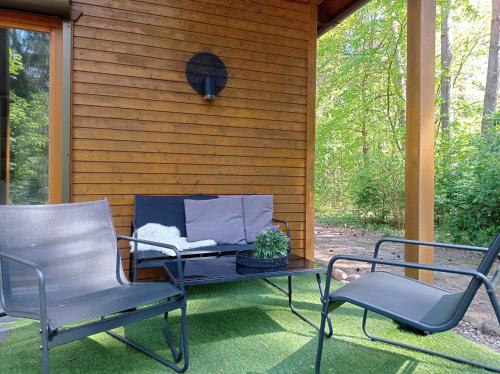 a patio with two chairs and a table on a porch at Wald und Wohlsein in Beelitz