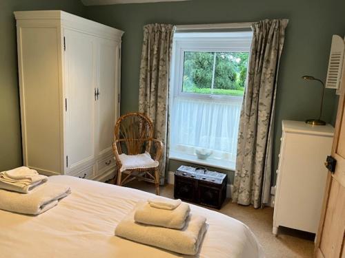 a bedroom with a bed with two towels on it at Amelie Cottage in Beaumaris
