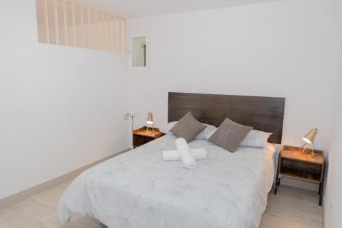 a bedroom with a large white bed with two night stands at Casa Luna Rural Con Piscina y Jardín in Ourense