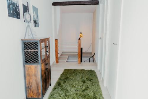 a hallway with a green rug on the floor at Casa Luna Rural Con Piscina y Jardín in Ourense