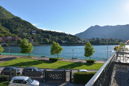 a view of a lake with cars parked on a street at Residenza Cece' in Lecco