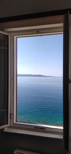 a window with a view of the ocean at Beach rooms Riviera - Žuta Kuća in Makarska
