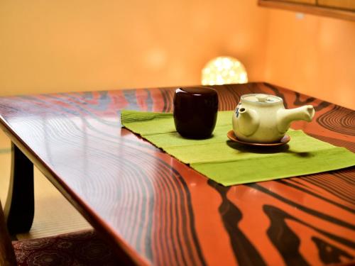 una mesa con una tetera y una taza en ella en Ｇｕｅｓｔ Ｈｏｕｓｅ Ｔａｋｅｎｏｙａ - Vacation STAY 43327 en Omachi