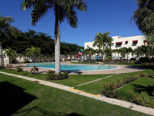 a swimming pool in a resort with palm trees at Apartamento céntrico Paradise k2 in Santiago de los Caballeros