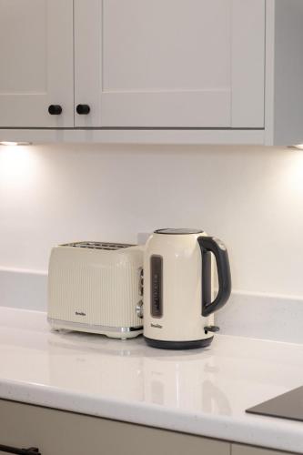 a slow cooker and toaster sitting on a kitchen counter at Charming Gateshead Retreat - Close to Newcastle - Angel of the North in Sheriff Hill
