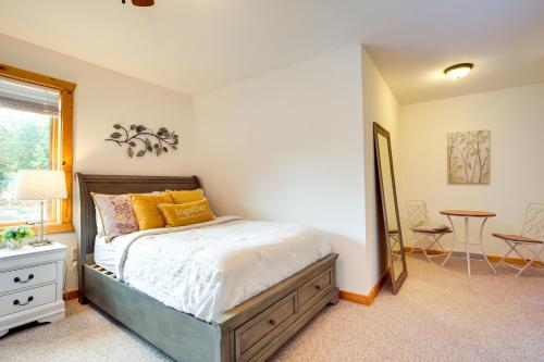 a bedroom with a bed with a mirror and a table at Lake Minocqua Condo with Shared Fire Pit! in Minocqua