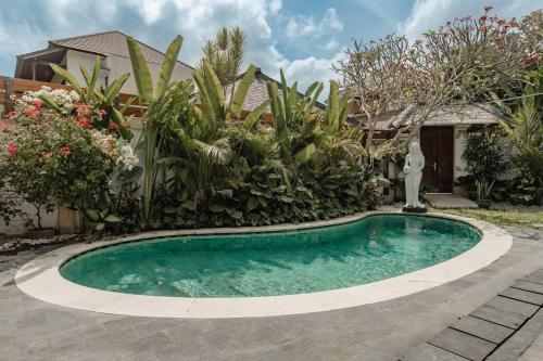 una piscina frente a una casa con jardín en Villa Nelayan Sands en Denpasar