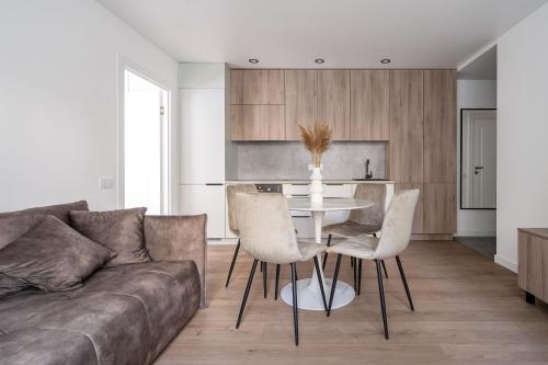 a living room with a couch and a table and chairs at Modern 2 bedroom Vytenio apartment in city centre I Self check-in in Vilnius