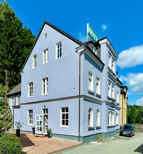 a large white building with a street sign on it at Villa Sachsenhof - Pension - Frühstück buchbar - nur 700m vom Gesundheitsbad ACTINON in Bad Schlema