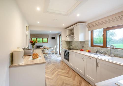 a kitchen with white cabinets and a large window at Bryn Penmaen in Pwllheli
