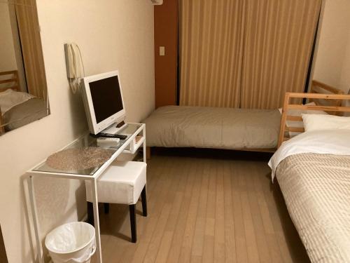 Habitación de hotel con escritorio, ordenador y cama en Sudomari Akariya - Vacation STAY 68896v, en Tanabe