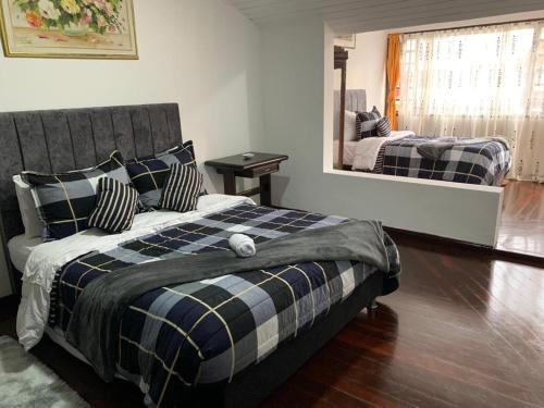 1 dormitorio con cama y espejo grande en Hostal Luxury Bogota, en Bogotá