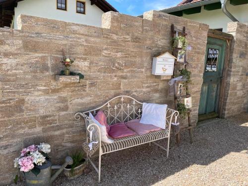 a bench sitting against a brick wall with pillows on it at Landgasthaus zur Linde in Pleiskirchen
