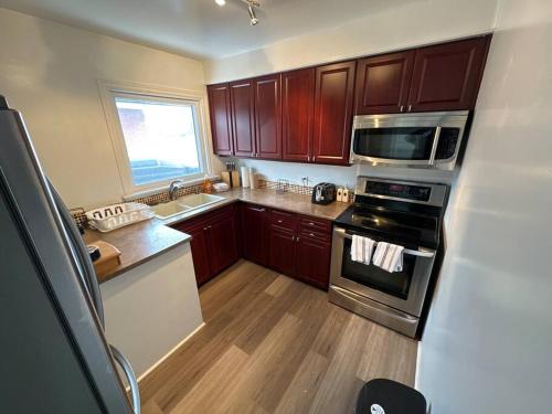 渥太華的住宿－3 Bedroom Near downtown Ottawa，厨房配有木制橱柜和炉灶烤箱。