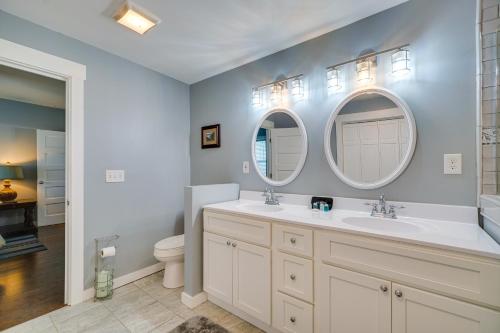 a bathroom with two sinks and two mirrors at Charming Knoxville Home 2 Mi to Neyland Stadium! in Knoxville