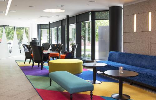 a lobby with a couch and tables and chairs at Thon Hotel Vika Atrium in Oslo