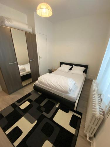 een slaapkamer met een bed en een zwart-wit tapijt bij Pavillon indépendant avec jardin au calme, proche Paris in Houilles