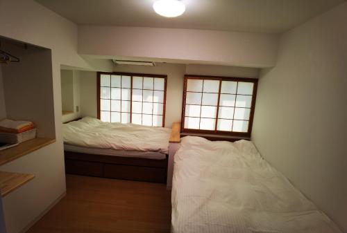 a small room with two beds and two windows at belle via tokyo - Vacation STAY 58509v in Tokyo